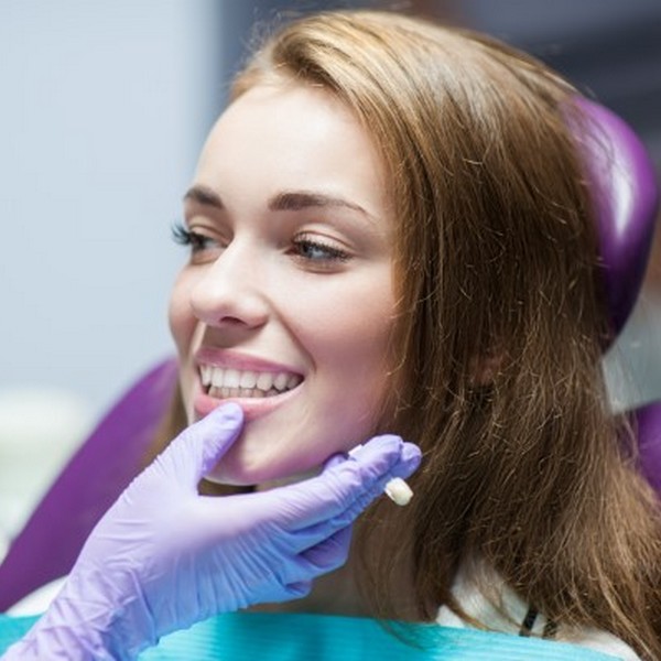 A woman is smiling in a dental chair