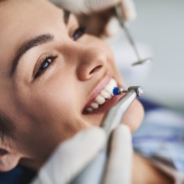 A woman is smiling in a dental chair